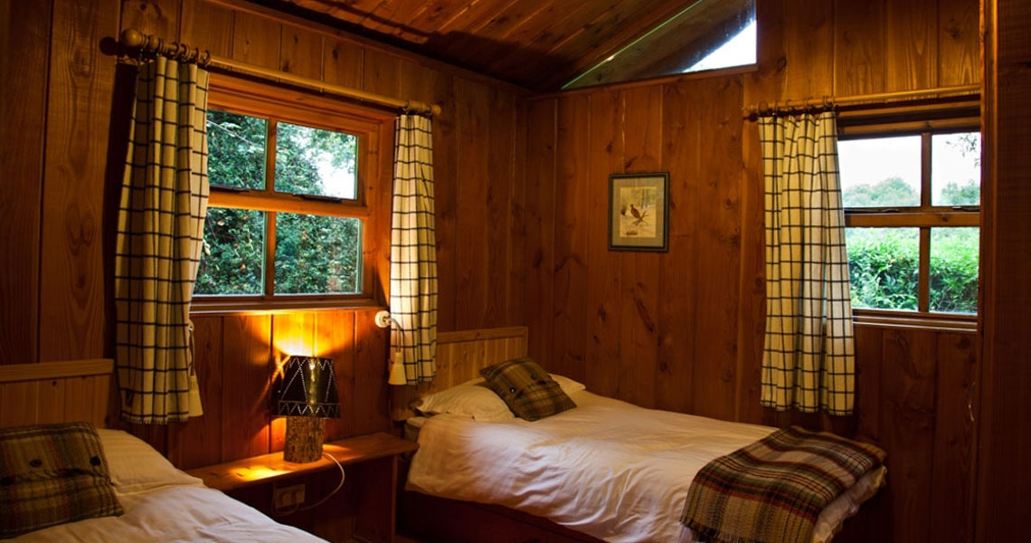Bedroom of wooden cabin at Carnakilla Cottages.