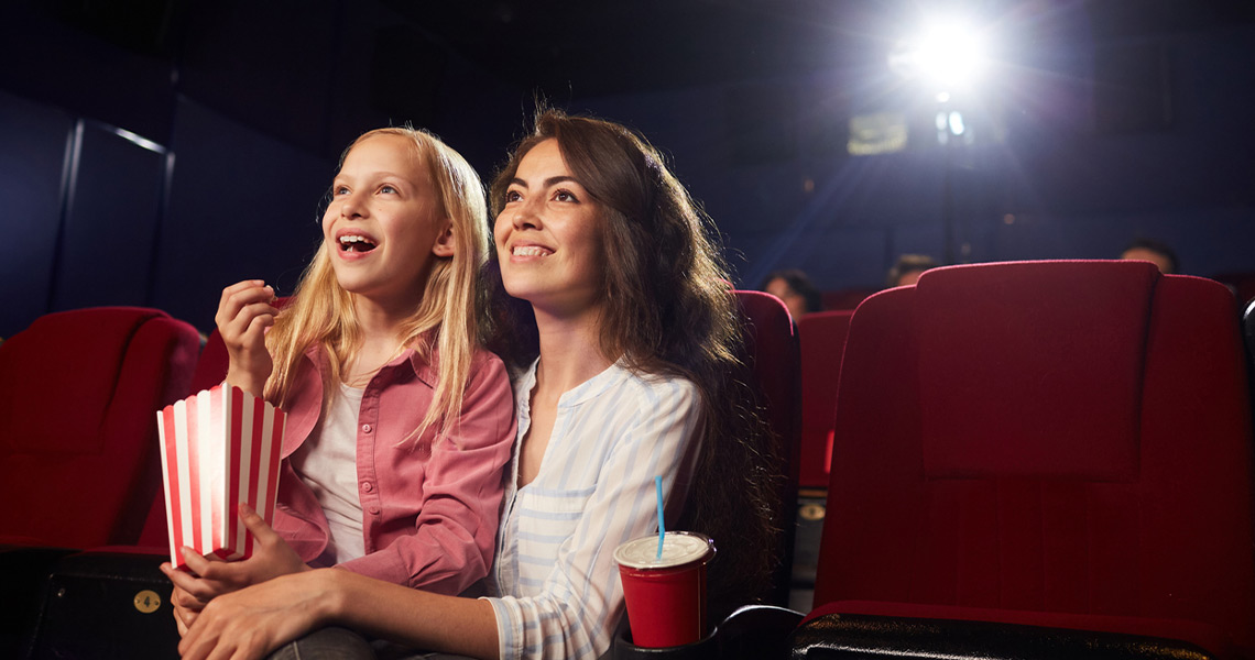 Mother and daughter enjoying movie.