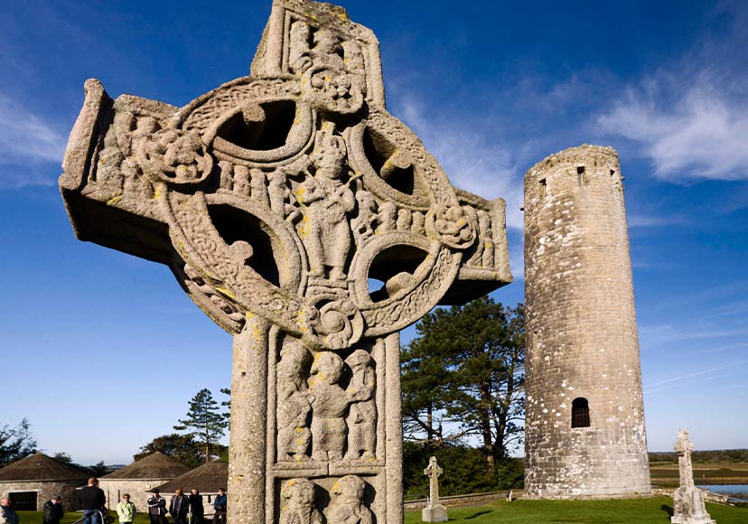 Close up of cross by round tower at Clonmacnoise.