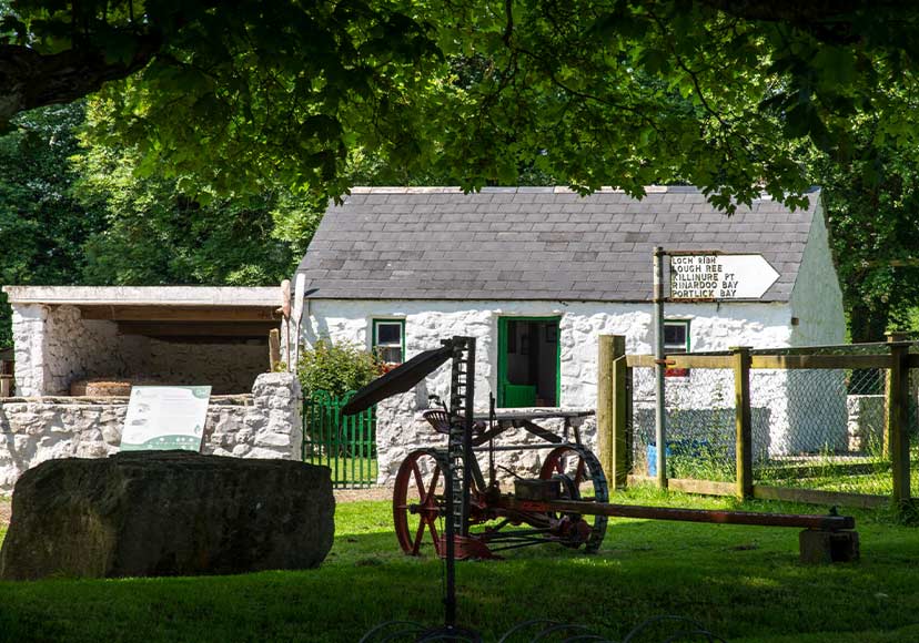Old stone house and farming equipment at Dún na Sí Amenity & Heritage Park.