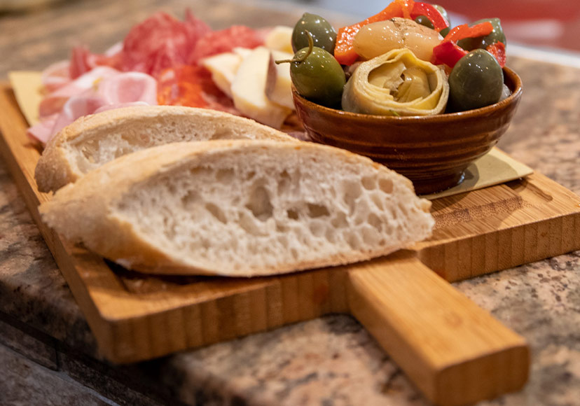 A breadboard of bread, olives and various italian hams at Il Colosseo.