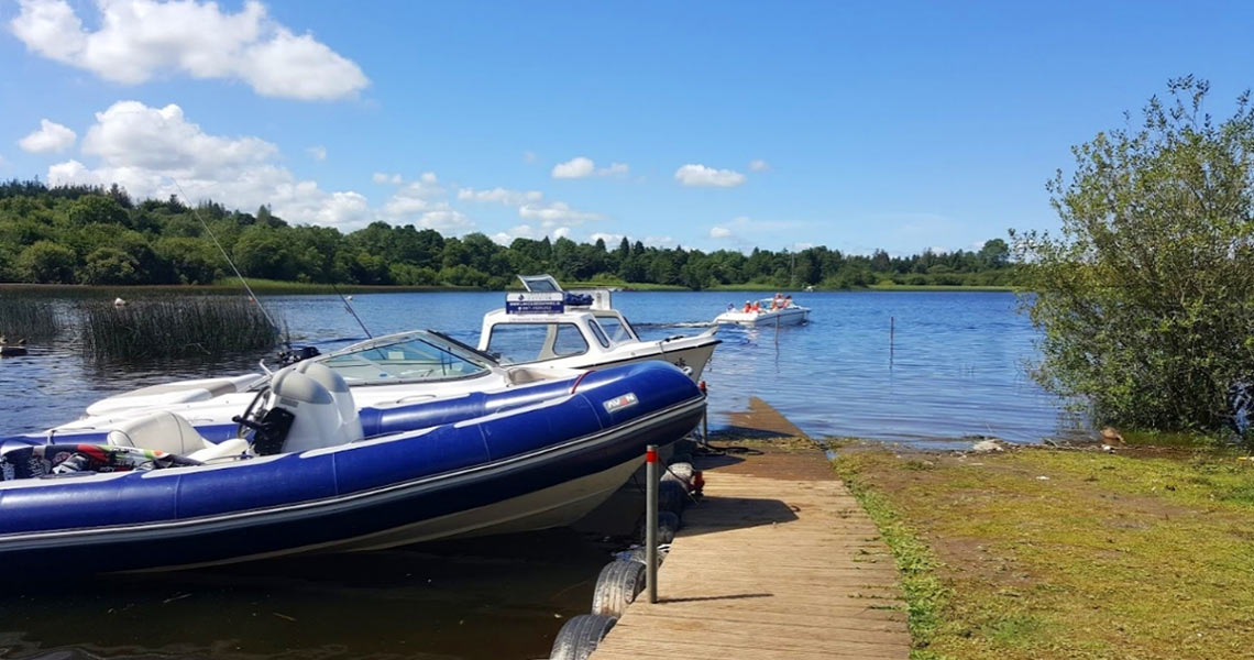 Boats by pier at Lough Ree East Caravan & Camping.