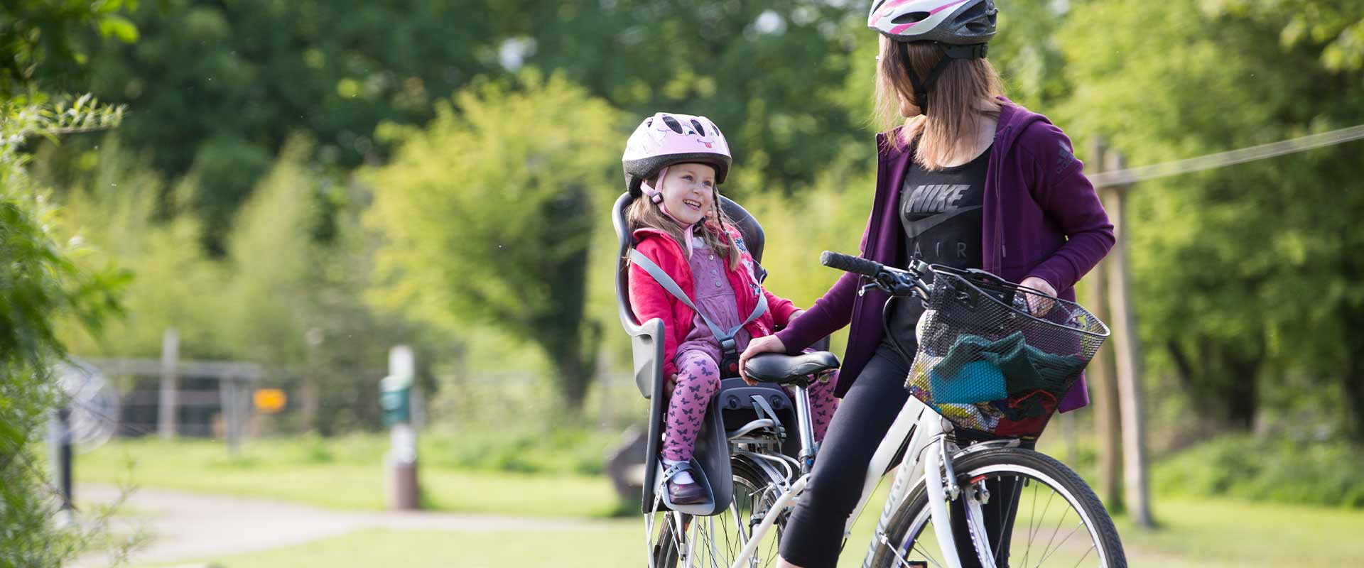 Mother cycling with daughter through Dún na Sí Amenity Heritage Park.