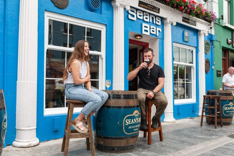 Two people drinking in front of Seans bar